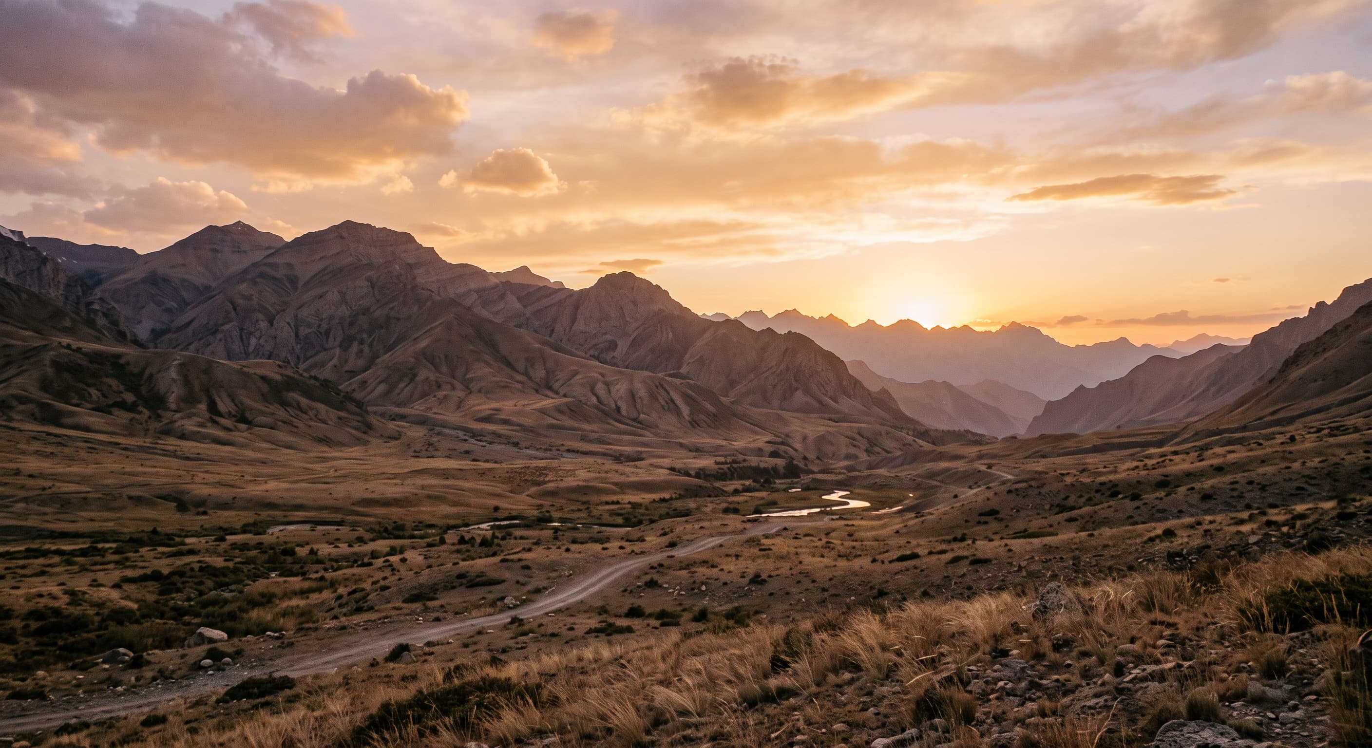 Paesaggio montuoso e arido dell'Afghanistan, cime rocciose e valle secca sotto un cielo sereno, senza persone né monumenti riconoscibili