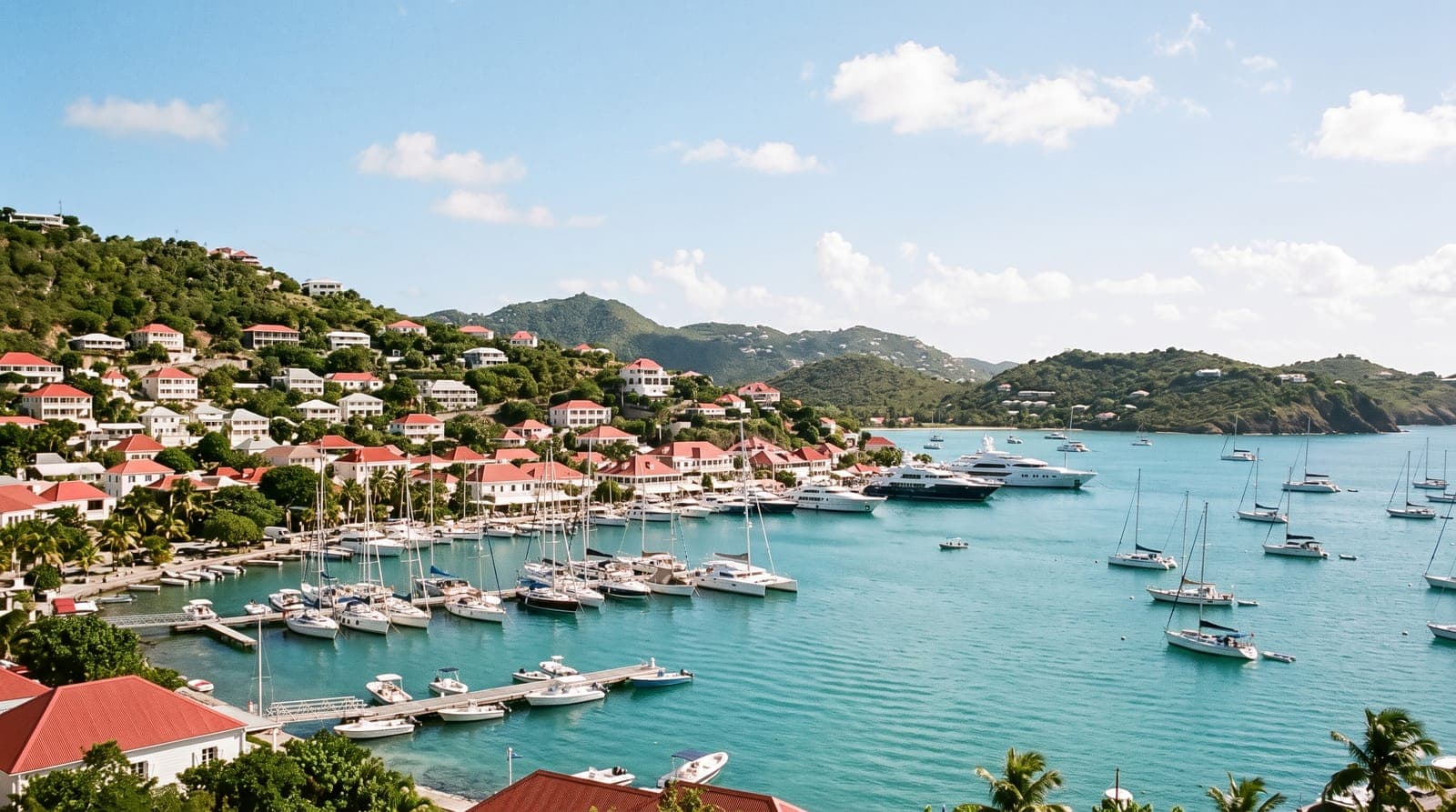 Bucht von Gustavia auf Saint-Barthélemy, ein Yachthafen mit Segelbooten und Yachten und weiße Häuser mit roten Dächern auf grünen Hügeln